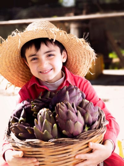 kid with basket of artichoke