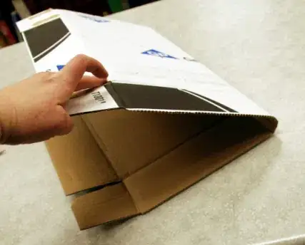 Image titled Scored lines allow the cardboard to bend easily into a "taco" shape.