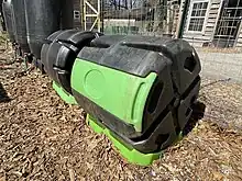 Compost rollers are used to cleanly produce rich, organic compost for sustainable gardens. Food waste, veggie scraps, grass clippings, cardboard, biochar, leaves and other biomass are mixed together. These inputs have varying levels of carbon and nitrogen which are required for producing compost. Microbes and insects break down these inputs into a rich soil amendment to help fertilize plants sustainably.